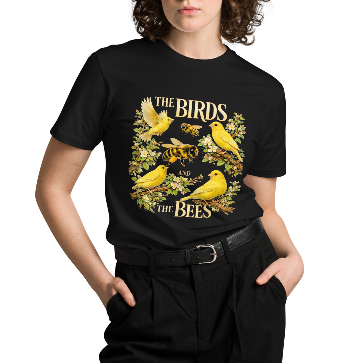Person wearing a black t-shirt with a yellow graphic design of birds and bees on a white background